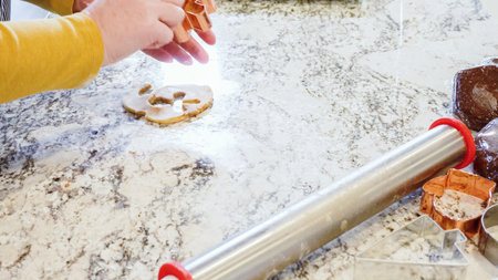 Using various festive cookie cutters, were cutting out charming gingerbread cookies from the rolled...