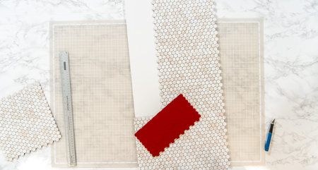 In the process of mounting peel and stick mosaic tiles onto a foam board, perfect for enhancing a...