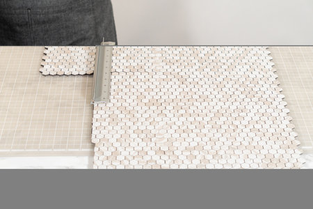 In the process of mounting peel and stick mosaic tiles onto a foam board, perfect for enhancing a...