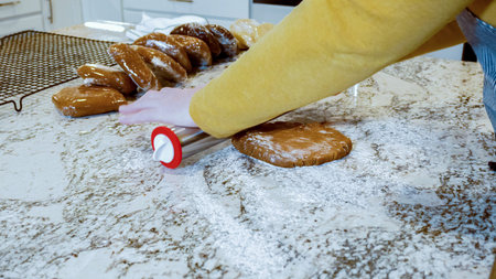 Using an adjustable rolling pin to roll out gingerbread cookie dough on the elegant marble counter...