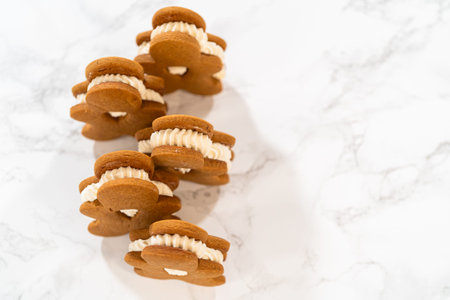 Gingerbread cookies filled with eggnog buttercream stand out, their rich hue complementing the...