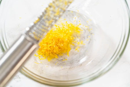 Integrating ingredients in a glass bowl, adeptly stirring with a whisk to craft a tantalizing lemon-blueberry bundt cake.の写真素材