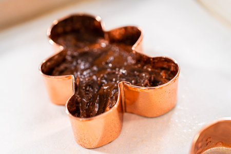 Filling cookie cutter with fudge mixture to prepare Christmas cookie-cutter peppermint fudge.