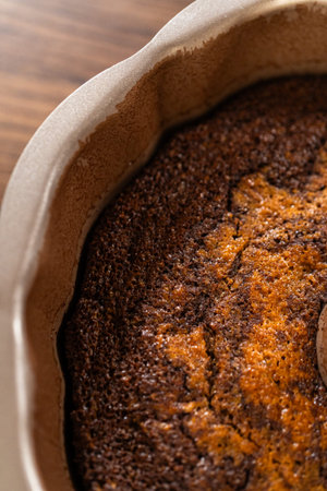 The gingerbread bundt cake cools gracefully on a wire rack, awaiting its sweet caramel frosting.