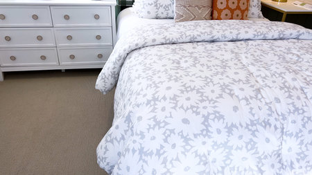 Cozy bedroom featuring a striking geometric headboard in green and white, complemented by a white...