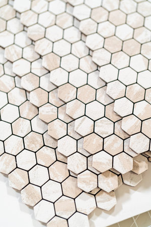In the process of mounting peel and stick mosaic tiles onto a foam board, perfect for enhancing a...