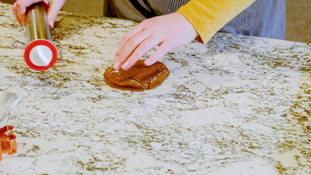 Using an adjustable rolling pin to roll out gingerbread cookie dough on the elegant marble counter...