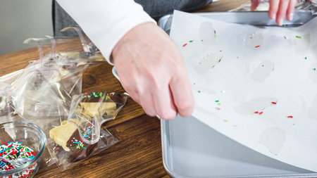 Carefully packaging Christmas cutout cookies, half-dipped in chocolate and presented in clear...