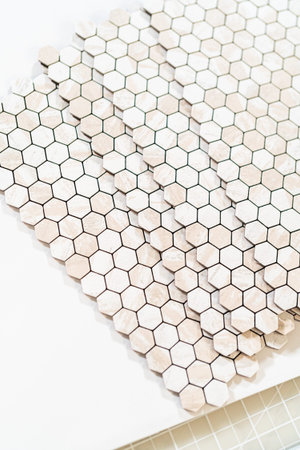 In the process of mounting peel and stick mosaic tiles onto a foam board, perfect for enhancing a food photography studios aesthetic.の写真素材