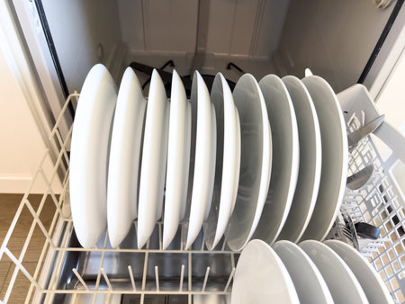 This image showcases a dishwasher filled with clean white dishes, neatly arranged in rows. Plates...