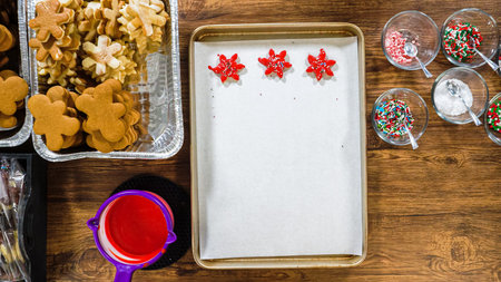 Flat lay. Creating snowflake-shaped cutout sugar cookies, dipped in chocolate, and adorned with...