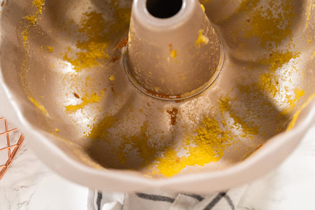 A close-up view of a dirty bundt cake pan after baking the pumpkin bundt cake.
