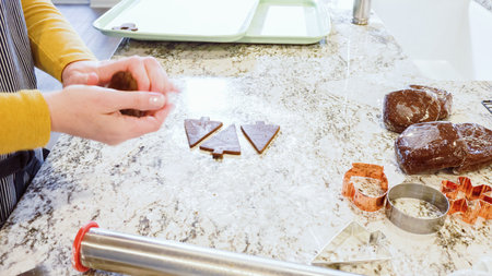 Using various festive cookie cutters, were cutting out charming gingerbread cookies from the rolled...