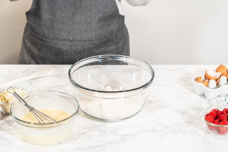 With a hand whisk, the measured ingredients come together - expertly mixed to prepare the cake...