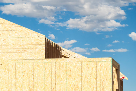An ongoing construction site in the suburbs, featuring the framing stage of a single-family house.