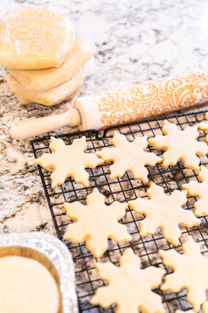 Letting delightful snowflake-shaped sugar cookies cool on a rack, preparing them for festive...