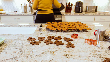 After baking to perfection, these delightful gingerbread cookies are now cooling gracefully on a wire rack, filling the modern kitchen with a warm and inviting aroma.の写真素材