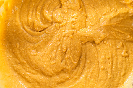 In a glass mixing bowl, a large hand whisk expertly blends the ingredients.の写真素材