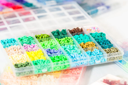 Assorted clay bead boxes neatly arranged on a white table, awaiting a creative kids craft project.