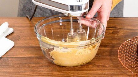 Whipping up salted caramel buttercream frosting in a glass mixing bowl.