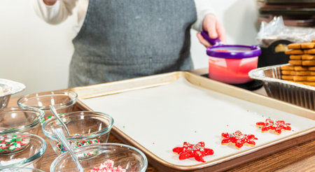 Vivid red star-shaped cookies, generously iced and speckled with green and white holiday sprinkles,...
