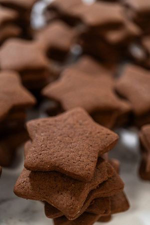A close-up view of a neatly stacked pile of gingerbread star cookies, emphasizing their rich, spiced texture and perfect shape.の写真素材