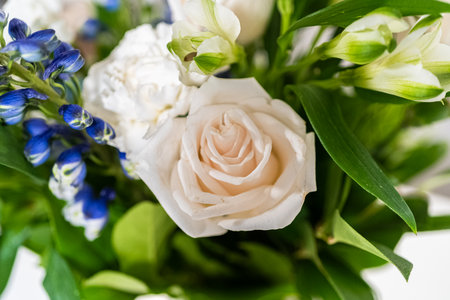 A stunning bouquet featuring fresh white roses and assorted flowers gracefully arranged in a vase, exuding timeless beauty.の写真素材