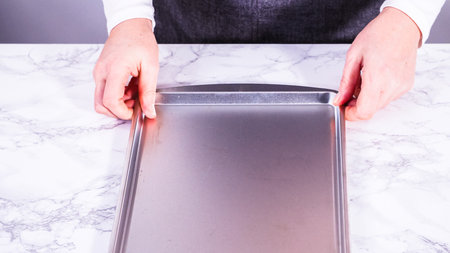 Juicy red strawberries, freshly washed, are spread out to dry on a baking sheet, carefully lined with paper towels to absorb excess moisture and prevent mold.の写真素材