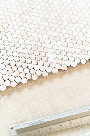In the process of mounting peel and stick mosaic tiles onto a foam board, perfect for enhancing a...