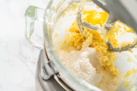 Close-up view of the stand mixer as dry ingredients are added to the wet mixture for Classic Sugar...