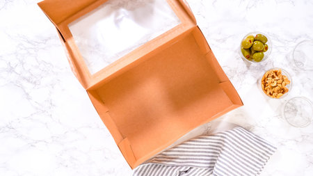 Flat lay. Hands are meticulously adding fresh red grapes to a bowl, complementing a beautifully...