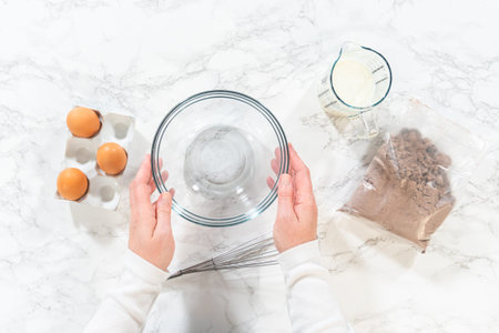 Flat lay. In the process of creating mouthwatering chocolate cupcakes, the first step involves...