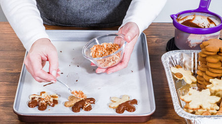 Crafting star-shaped holiday cookies dipped in chocolate and sprinkled with variety of toppings.