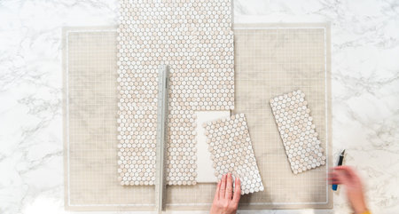 In the process of mounting peel and stick mosaic tiles onto a foam board, perfect for enhancing a...