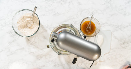 Overhead view of a stand mixer and prepared ingredients for Amber Gingerbread Cookie Dough, ready...