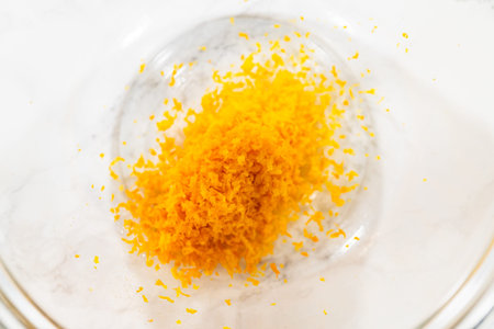 A close-up of bright orange zest in a glass bowl, which will add a zesty flavor to the Zesty Orange...