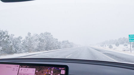 POV-Electric vehicle is captured deftly navigating the I-70 highway during a winter storm in Western Colorado.の写真素材