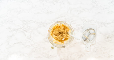 Top view of an electric mixer and bowls containing ingredients for Classic Sugar Cookie Dough. The...