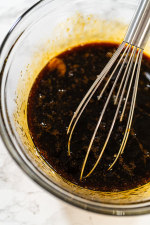 A top-down view of dark molasses and two eggs in a glass bowl, part of the wet ingredients for Zesty Orange Gingerbread Cookie Dough. The molasses adds depth and a rich color to the gingerbread.の写真素材