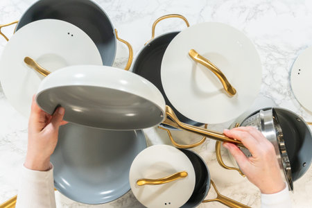 Two hands lift a ceramic skillet with a gold handle, highlighting the nonstick surface and stylish...