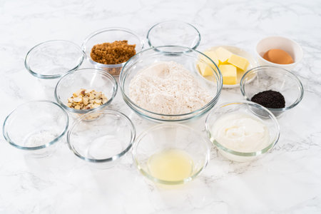 Measured ingredients in glass mixing bowls to bake lemon poppy seed muffins.