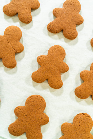 Straight-on view of freshly baked gingerbread man cookies, showcasing the festive design and even...