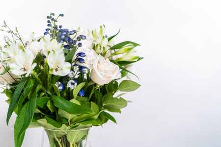 A stunning bouquet featuring fresh white roses and assorted flowers gracefully arranged in a vase, exuding timeless beauty.の写真素材