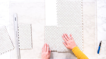 Flat lay. In the process of mounting peel and stick mosaic tiles onto a foam board, perfect for...