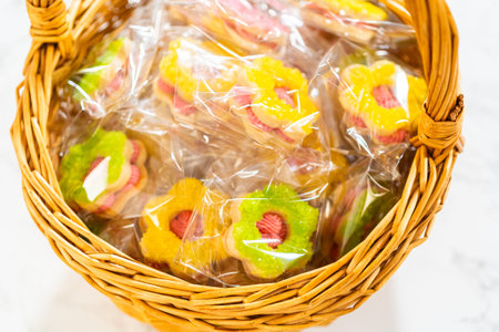 Colorful flower-shaped Easter cookie sandwiches with raspberry buttercream filling, individually...