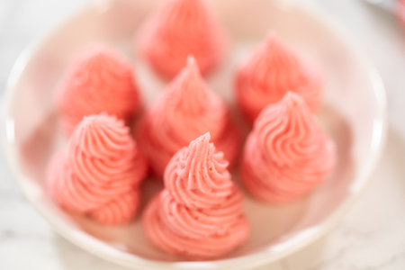 Blurred top view image showing the dreamy presentation of raspberry buttercream swirls for Easter Cookie Sandwich with Raspberry Buttercream. Suitable for creative or lifestyle baking content.の写真素材