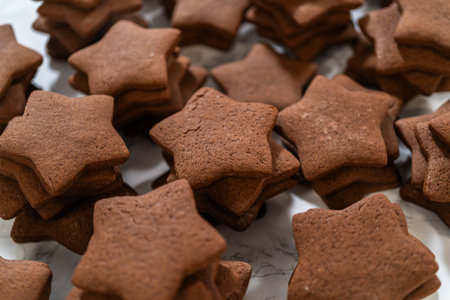 A close-up view of a neatly stacked pile of gingerbread star cookies, emphasizing their rich, spiced texture and perfect shape.の写真素材