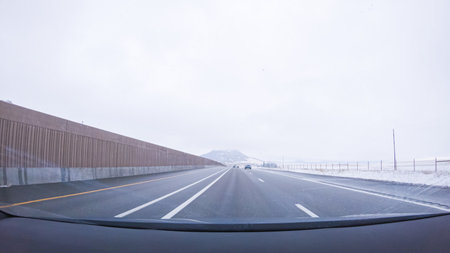 The open highway invites a peaceful drive, with snow-clad pines lining I-25 as the journey continues from Denver towards Colorado Springs on a snowy day.の写真素材