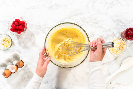Flat lay. With a hand whisk, the measured ingredients come together - expertly mixed to prepare the...