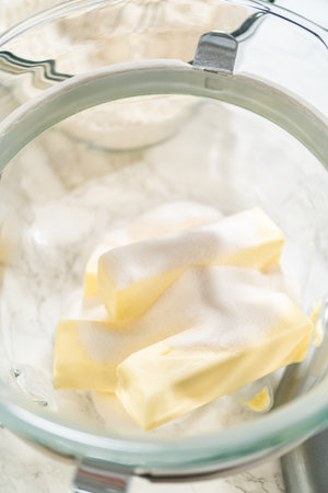 Creaming butter and sugar together in a stand mixer bowl for Easter Cookie Sandwich with Raspberry Buttercream. This classic baking technique creates a light and airy base.の写真素材